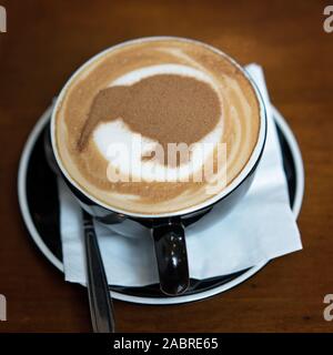 Una tazza di caffè cappuccino con un kiwi in cioccolato spruzza, Nuova Zelanda Foto Stock