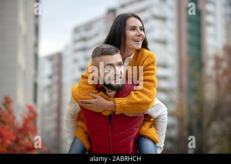 Tanto divertimento. Bella giovane donna di mantenere il suo ragazzo mentre viene trattenuto da lui Foto Stock