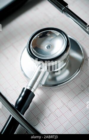 Close up di un elettrocardiogramma in forma cartacea e uno stetoscopio. Foto Stock