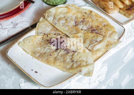 Piastra con qutab .tradizionale cucina azerbaigiana. Vista superiore colpo di qutabs -flatbread sulla piastra bianca tradizionale il qutab riempiti con carne e Foto Stock