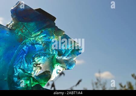 Colori riflessi sul cielo dello sfondo. Trasparenza gioco con blu, verde e bianco in vetro. Foto Stock