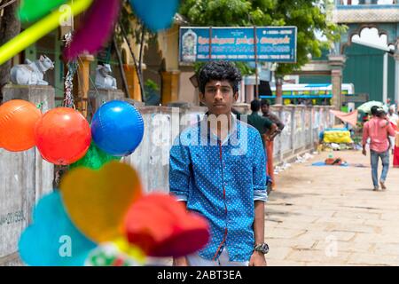 In plastica colorata e il mulino a vento di palloncino con bellissimo Indian boy guardando la fotocamera su sfondi del tempio Foto Stock