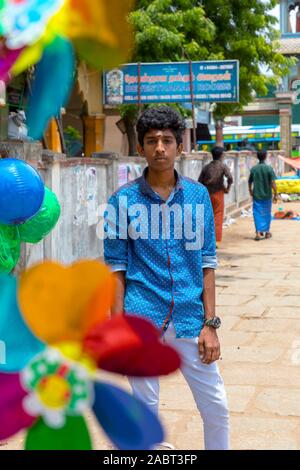 Colorate il mulino a vento di plastica con bellissimo Indian boy guardando la fotocamera su sfondi del tempio Foto Stock