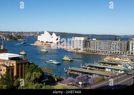 Vista del porto di Sydney - i traghetti che arrivano e partono da Circular Quay e la Sydney Opera House in una giornata di sole in estate, Sydney Australia Foto Stock