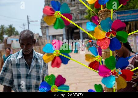 Carta Pinwheels mantenuto sul display da un fornitore nel tempio indiano sfondi Foto Stock