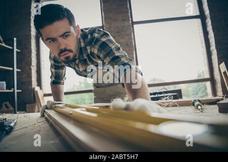 Close-up ritratto della sua egli bella attraente focalizzato serio esperto laboriosa repairman controllando la levigatezza plank creazione di nuova costruzione casa avviare Foto Stock