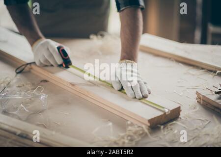 Ritagliato vista ravvicinata della sua egli bella mani guanti giuramento esperto ragazzo esperto esperto listone di misurazione bordo la costruzione di un nuovo progetto di casa start-up a Foto Stock