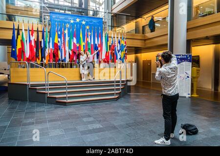 Un gruppo di tour in posa per fotografie con le bandiere degli Stati membri dell'UE, il Parlamento europeo, Strasburgo, Alsazia, Grand Est, Francia Foto Stock