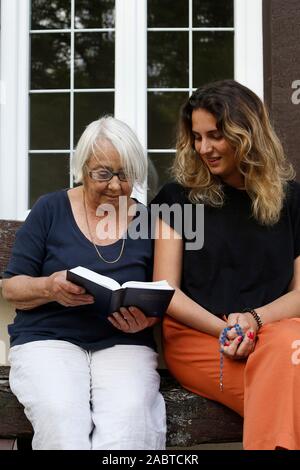 Senior e giovane donna leggendo la Bibbia in Eure, Francia Foto Stock