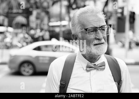 Bello barbuto senior uomo turistica di esplorare la città in bianco e nero Foto Stock