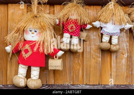 Tre bambole di tessili in bianco e rosso T-shirt con piccole scatole di legno. Foto Stock