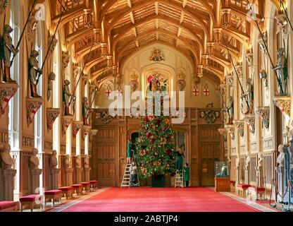 Un Royal Collection Trust membro del personale mette i tocchi di rifinitura di 20ft Nordmann abete, originati dal Windsor Great Park, a St George's Hall presso il Castello di Windsor, Berkshire. Foto Stock