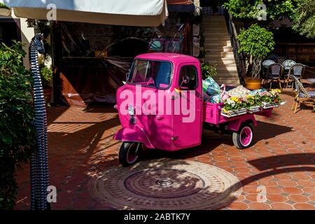 Piaggio Ape di colore rosa con fiori e le cose per la vendita in linea. Posizionamento sulla strada in Turchia, Alanya Foto Stock