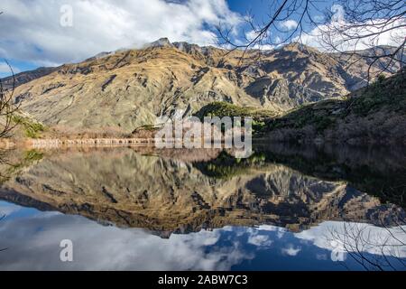 Rocky Mountain Range perfetto riflesso in diamante vicino lago di montagna rocciosa, Wanaka, montare gli aspiranti National Park, Nuova Zelanda Foto Stock