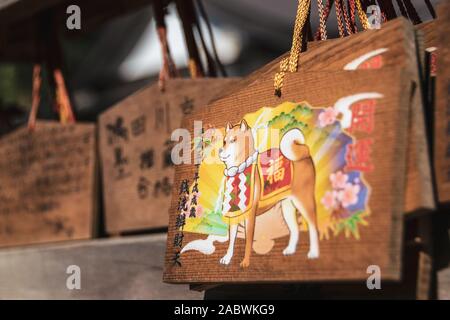 Close-up su un colorato lapide votiva raffigurante un Shiba Inu cane. "Ema" le placche sono comunemente per la scrittura di auguri da lo shintoismo credenti. Foto Stock