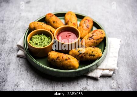 Frittatine di riso flated o POHA di verdure servite con ketchup di pomodoro e chutney verde Foto Stock