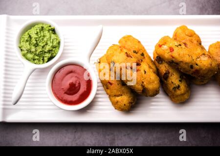 Frittatine di riso flated o POHA di verdure servite con ketchup di pomodoro e chutney verde Foto Stock