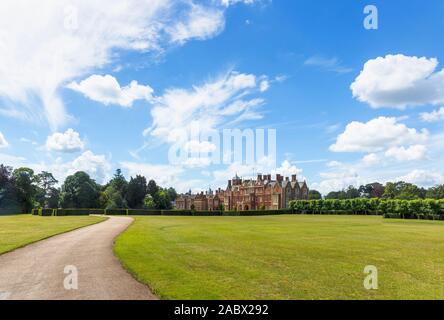 Vista panoramica di Sandringham House, ingresso drive e prato, un country house, Queen's Norfolk ritiro, in estate con un cielo blu e nuvole bianche Foto Stock