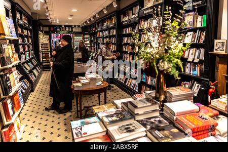 I clienti libri di esplorazione in Hatchards bookshop, Piccadilly, Londra, Inghilterra, Regno Unito. Foto Stock