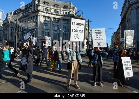 Londra, Regno Unito. Il 29 novembre 2019. Membri della ribellione di estinzione inscenare una protesta a Oxford Circus sul Venerdì nero. Gli attivisti protestano contro usa e getta di moda e di un eccessivo consumo dei consumatori il giorno quando i rivenditori stanno offrendo notevoli sconti sui loro prodotti. Credito: Stephen Chung / Alamy Live News Foto Stock