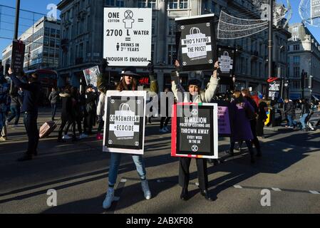 Londra, Regno Unito. Il 29 novembre 2019. Membri della ribellione di estinzione inscenare una protesta a Oxford Circus sul Venerdì nero. Gli attivisti protestano contro usa e getta di moda e di un eccessivo consumo dei consumatori il giorno quando i rivenditori stanno offrendo notevoli sconti sui loro prodotti. Credito: Stephen Chung / Alamy Live News Foto Stock