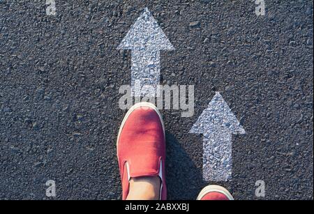 Scarpe permanente al crocevia e arrivare alla decisione che la strada da percorrere. Modi per scegliere il concetto. Foto Stock