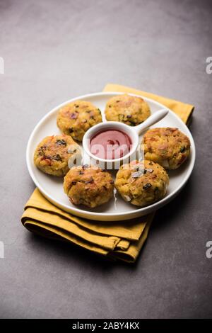 Frittatine di riso flated o POHA di verdure servite con ketchup di pomodoro e chutney verde Foto Stock