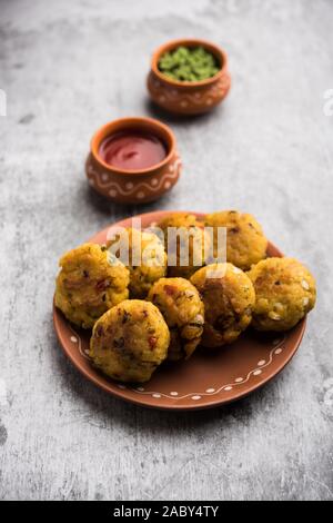 Frittatine di riso flated o POHA di verdure servite con ketchup di pomodoro e chutney verde Foto Stock