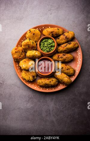 Frittatine di riso flated o POHA di verdure servite con ketchup di pomodoro e chutney verde Foto Stock