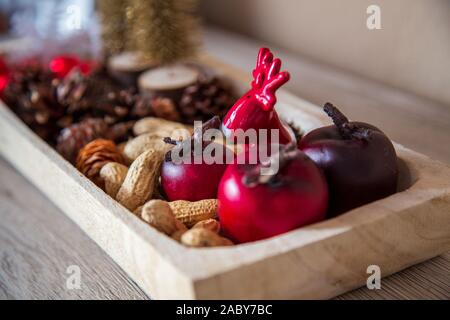 Decorazione di Natale per la casa. Con luci e palline corona di Avvento e un angelo. Decorata splendidamente in ciotole di legno. Foto Stock