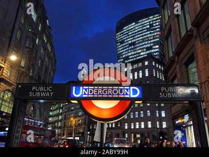 Segno della metropolitana di Londra di TfL di vecchio stile, al crepuscolo nella città di Londra, stazione della metropolitana della banca, distretto finanziario della città di Londra dietro, Inghilterra, Regno Unito Foto Stock