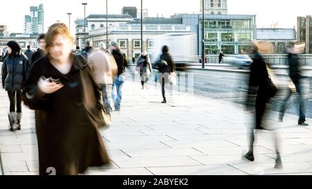 Pedone Rush Hour. Abstract lunga esposizione dell ufficio di Londra e i lavoratori pendolari su London Bridge durante un inverni freddi giorno. Foto Stock