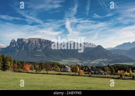 Vista panoramica dello Sciliar montagna del massiccio e il villaggio Voels am Schlern in Alto Adige si vede dal Renon su una luminosa giornata autunnale Foto Stock