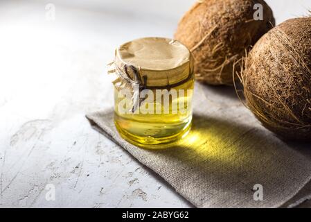 Le noci di cocco e bottiglia di palme di cocco olio. cibo sano vegan concetto aromaterapia Foto Stock