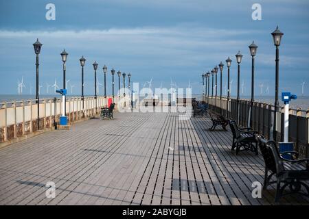 Uomo di mezza età seduto su una panchina alla fine di Skegness Pier nella tradizionale cittadina balneare di Skegness, Lincolnshire, Engand UK. Foto Stock