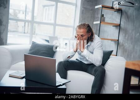 Foto del giovane imprenditore seduto sul pullman e ha sottolineato durante il lavoro Foto Stock