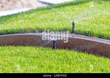 La metropolitana di irrigazione sistema sprinkler, innaffiamento automatico park prato. Foto Stock