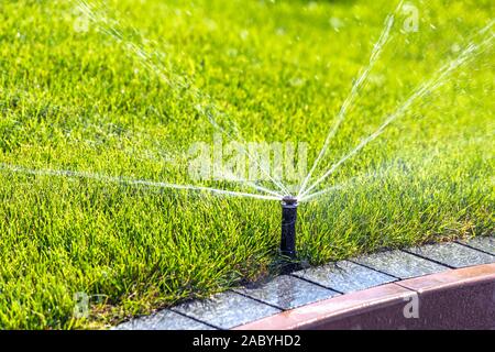 Metropolitana sistema sprinkler, innaffiamento automatico park prato. Foto Stock