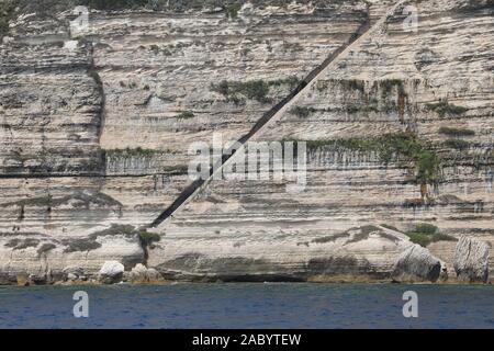 Lunga scalinata sulla roccia nella città di Bonifacio in Corsica e il mare in estate Foto Stock