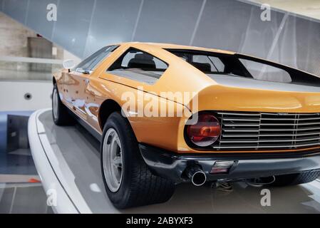 Vista posteriore e laterale del giallo retrò sport coupe con parte posteriore sinistra, retroilluminazione porte verticali, pneumatici larghi, disco cromato e specchio Foto Stock