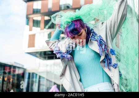 Una femmina modello XR di eseguire durante la mostra.A Utrecht, estinzione della ribellione Nederland ha organizzato un XR azione di moda, contro il consumismo durante il Black Friday, nella parte anteriore del Hoog Catharijne shopping mall il quale è uno dei la più grande piscina centri commerciali nei Paesi Bassi. Tutti i vestiti che hanno usato era di seconda mano e up-ciclati i vestiti. Questo segue il venerdì per il futuro, la gioventù clima movimenti di sciopero. Foto Stock