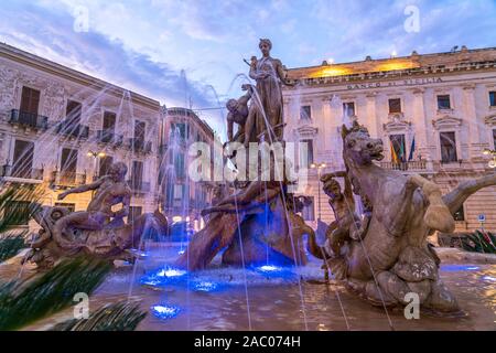 Artemisbrunnen auf dem Platz Piazza Archimede in der Abenddämmerung, Insel Ortigia, Syrakus, Sizilien, Italien, Europa | Fontana di Artemis su Arch Foto Stock