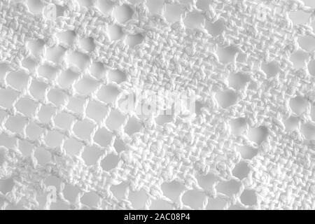 Extreme close up di una maglia bianca tovaglia su sfondo bianco Foto Stock