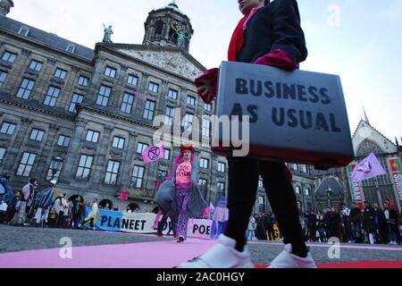 Estinzione della ribellione attivisti eseguire durante il 'Venerdì nero Rebellion' in Piazza Dam nel novembre 29, 2019 in Amsterdam, Paesi Bassi. Manifestanti cal Foto Stock