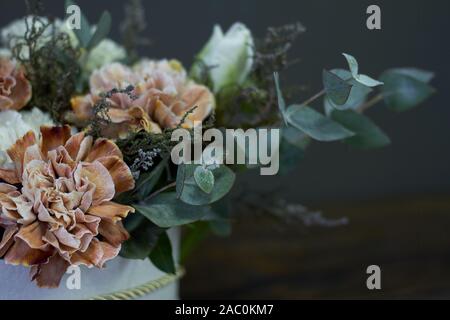 Una scatola con un bouquet vintage su uno sfondo scuro, il fuoco selettivo Foto Stock
