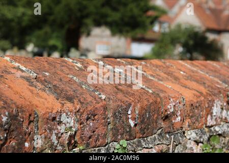 Vecchio cotto spiovente muro di mattoni nel villaggio inglese Foto Stock