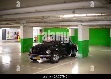 Strasburgo, Francia - Dic 21, 2016: vista anteriore di nero trasformabile cabriolet Volkswagen maggiolino mini auto parcheggiate nel sotterraneo vuoto parete verde parcheggio Foto Stock