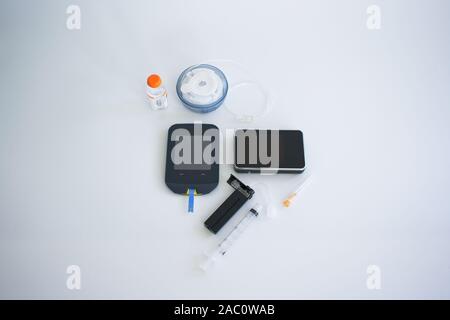 Pompa di insulina attrezzature e il livello di glucosio nel sangue tester Foto Stock