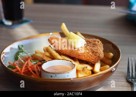 Fritti di filetto di pesce con patatine fritte e verdure sulla piastra in ristorante Foto Stock