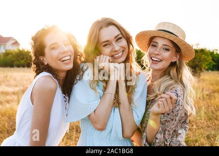 Foto di gioiosa belle donne sorridente e guardando la telecamera sulla campagna durante la giornata di sole Foto Stock